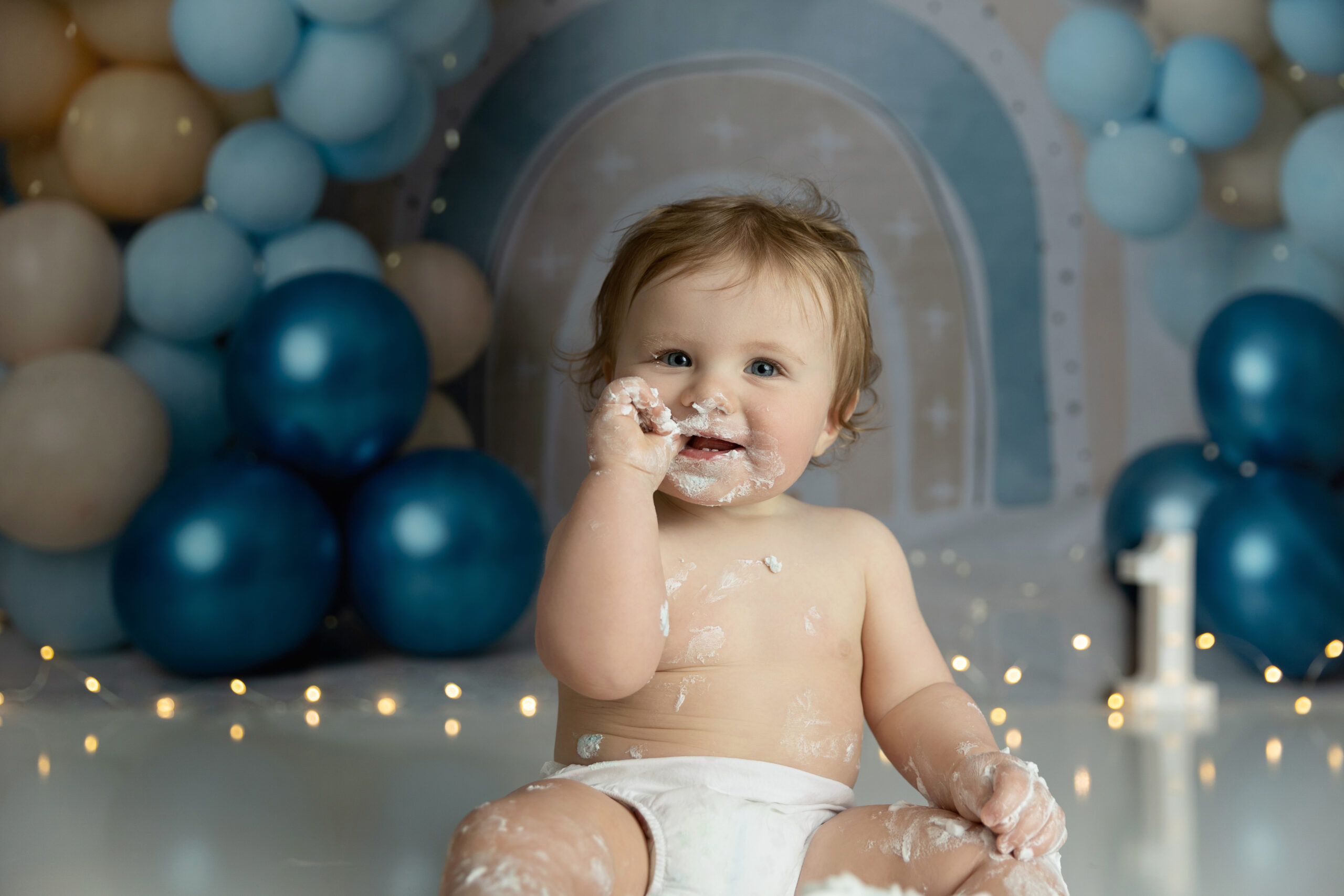 First birthday boy having fun during his cake smash session in an NJ photo studio.