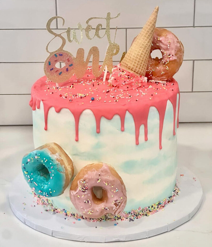 NJ baker's 1st birthday cake with icing drip and donuts on top for a sweet one themed party.