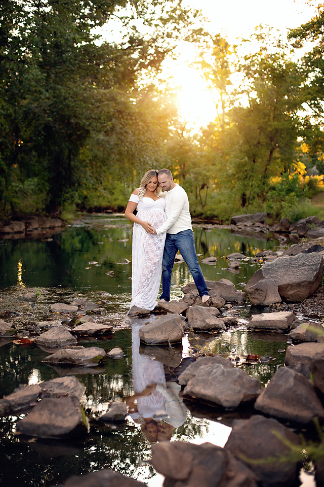 expecting mother & father to be posing for maternity photos on a stream.